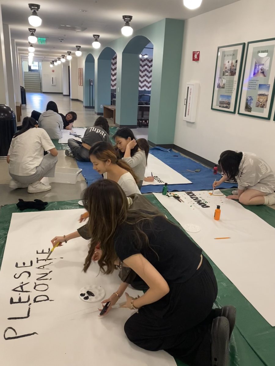 Community Service club members painting posters for the Halloween donation.