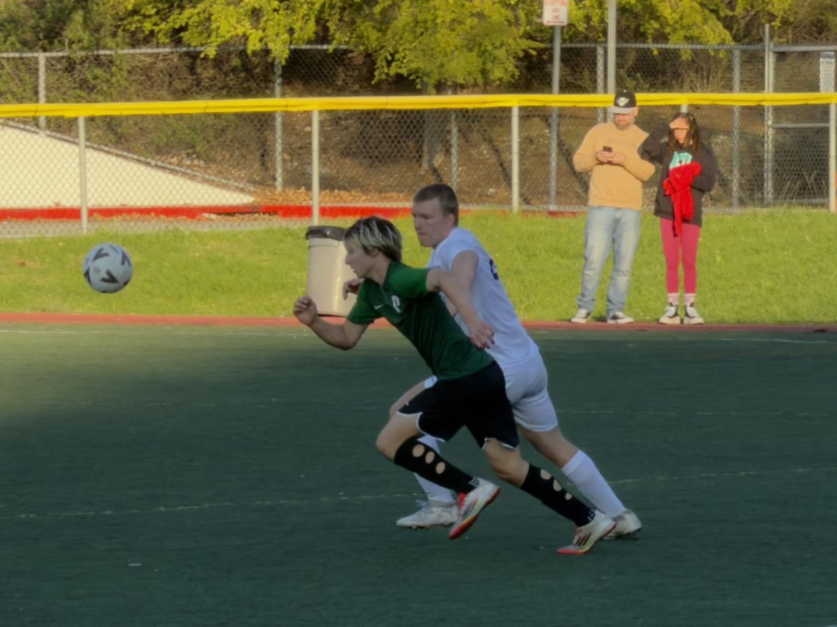 Thorvald Larsen of EF Academy runs alongside a Providence player as they chase a loose ball during the match.